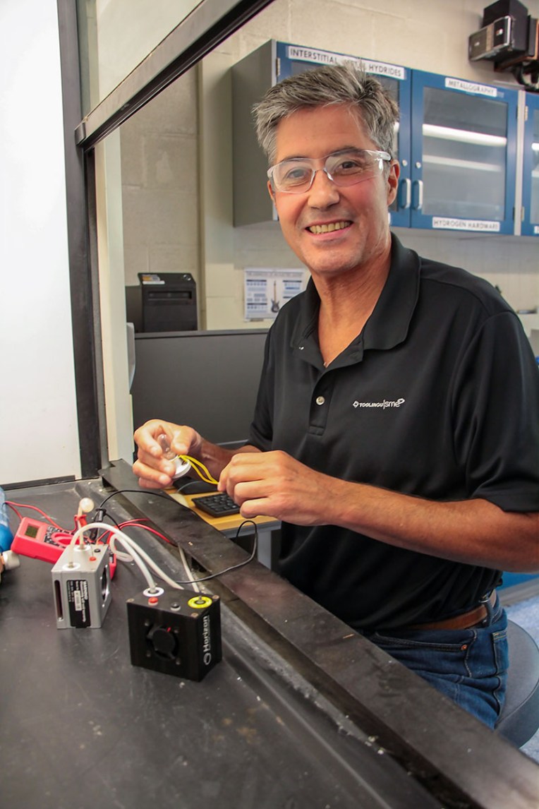 Man wearing safety glasses sitting in front of small equipment