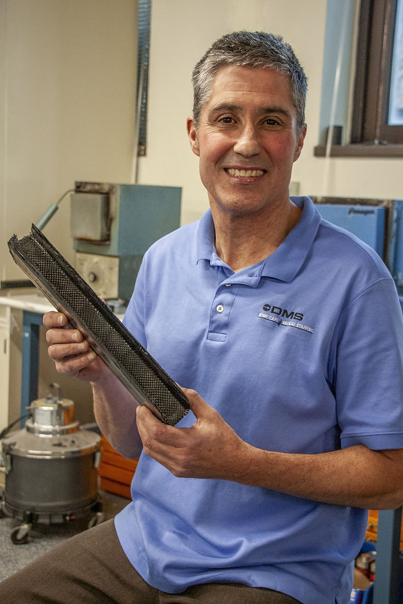 Man holds a long carbon fiber mold